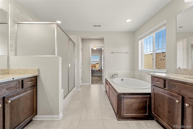 bathroom with visible vents, vanity, a shower stall, and a garden tub