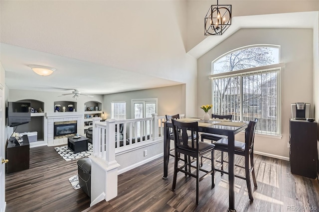 4708 Rock Pipit Ct, Highlands Ranch, CO 80126 - dining room featuring ceiling fan, plenty of natural light, dark wood finished floors, a tiled fireplace, and a towering ceiling