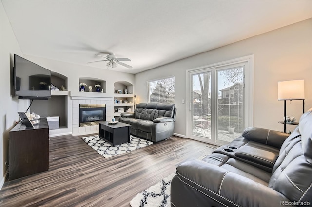 4708 Rock Pipit Ct, Highlands Ranch, CO 80126 - living room with healthy amount of natural light, a ceiling fan, dark wood-type flooring, and a fireplace