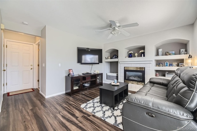 4708 Rock Pipit Ct, Highlands Ranch, CO 80126 - living area with dark wood-type flooring, a ceiling fan, baseboards, built in shelves, and a tile fireplace