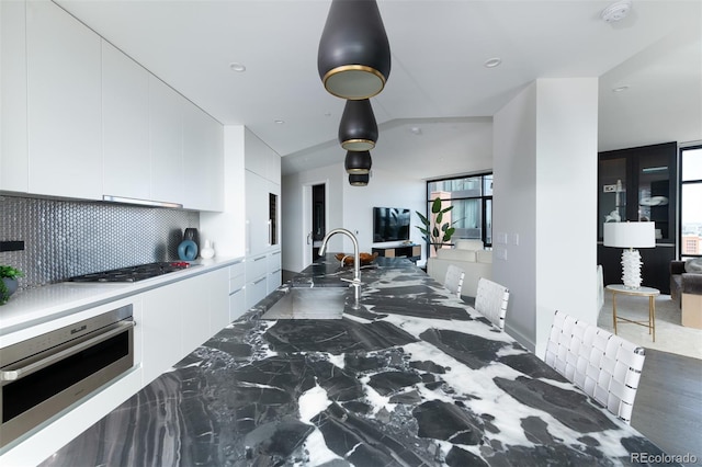 kitchen with stainless steel appliances, a sink, white cabinets, decorative backsplash, and modern cabinets