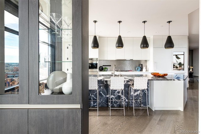 kitchen with light wood-style flooring, decorative backsplash, white cabinets, modern cabinets, and oven