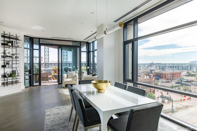 dining room with expansive windows, wood finished floors, and a view of city