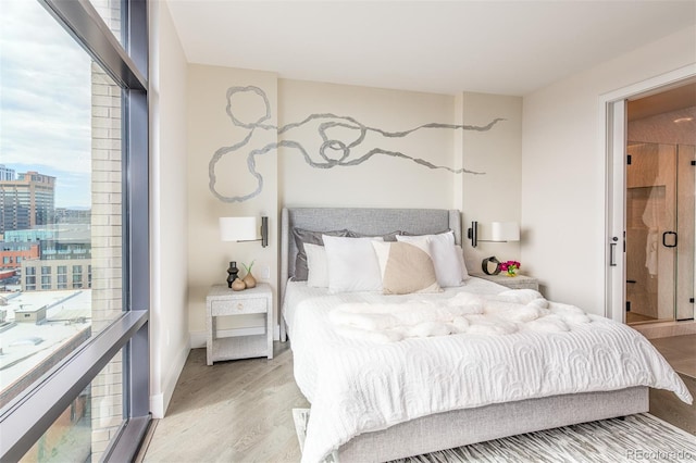 bedroom with light wood-style floors and a view of city