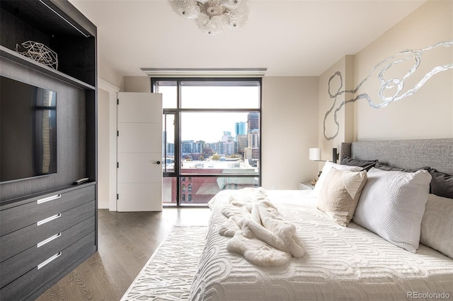 bedroom featuring a view of city and wood finished floors