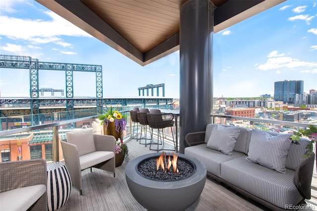 balcony featuring a view of city and an outdoor living space with a fire pit