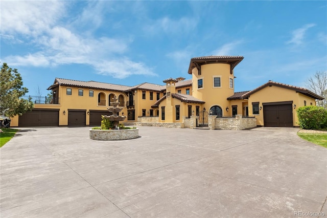 mediterranean / spanish-style house featuring stucco siding, concrete driveway, and a tile roof