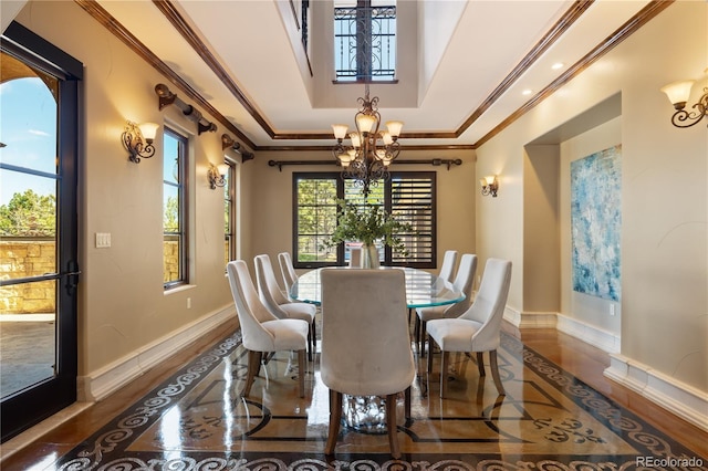dining room featuring baseboards, ornamental molding, a raised ceiling, and a chandelier