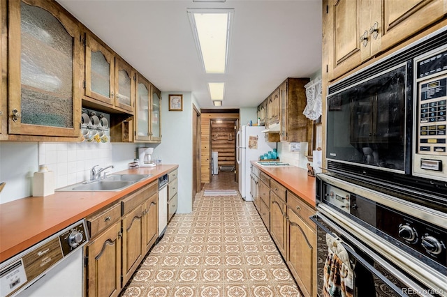 kitchen featuring white appliances, glass insert cabinets, brown cabinets, a sink, and backsplash
