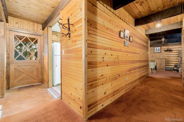 hallway with wood ceiling, wood walls, carpet, and beamed ceiling