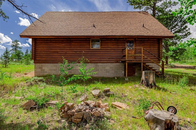 exterior space featuring log exterior and roof with shingles