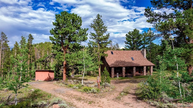 view of yard with a porch and dirt driveway