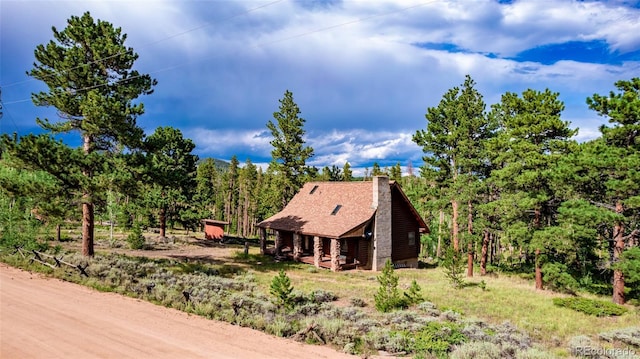 exterior space with a chimney and a forest view