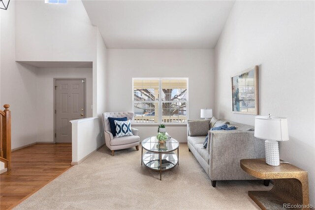 living area with carpet, visible vents, baseboards, and wood finished floors