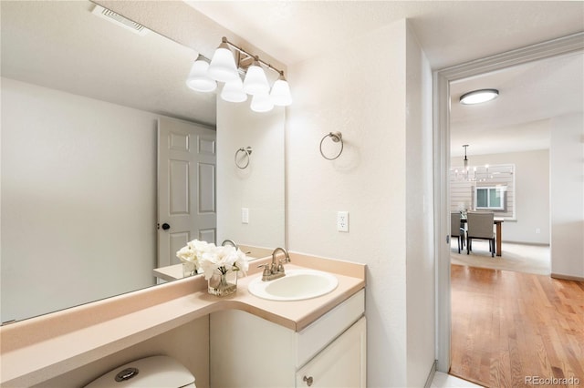 bathroom with an inviting chandelier, visible vents, and vanity