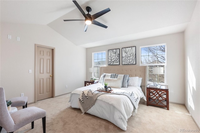 bedroom featuring light colored carpet, vaulted ceiling, baseboards, and ceiling fan