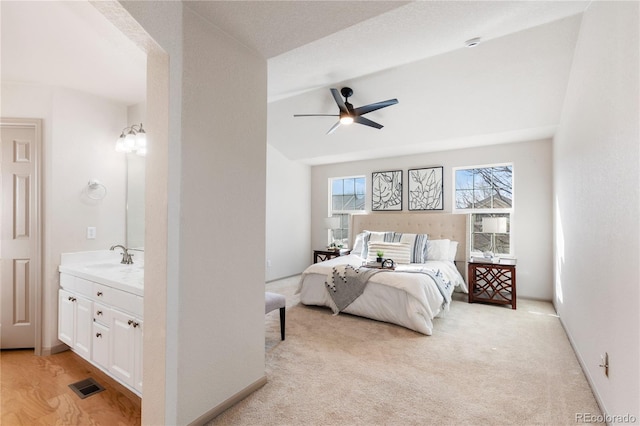 bedroom featuring baseboards, a sink, visible vents, and light colored carpet