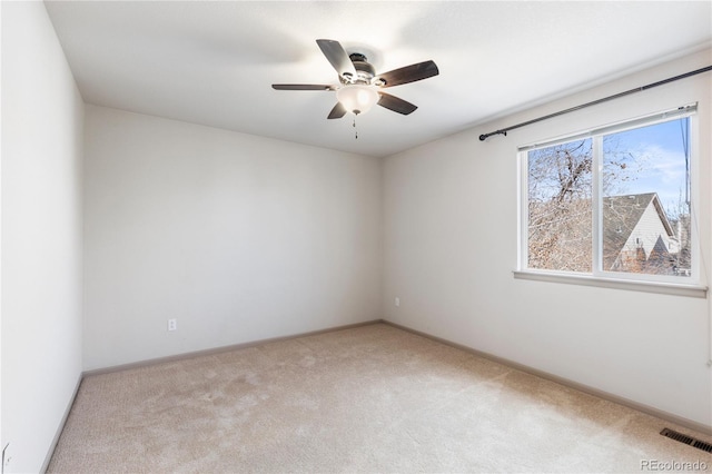 spare room featuring ceiling fan, baseboards, visible vents, and light colored carpet