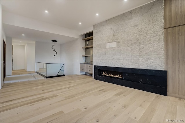 unfurnished living room featuring a fireplace, wood finished floors, and recessed lighting