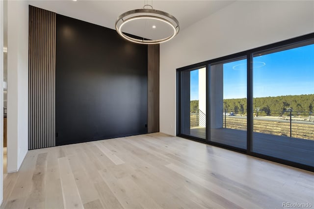 empty room featuring wood finished floors and a towering ceiling