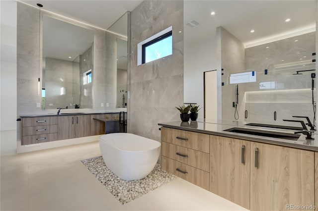 bathroom with a freestanding tub, recessed lighting, vanity, tile walls, and a stall shower