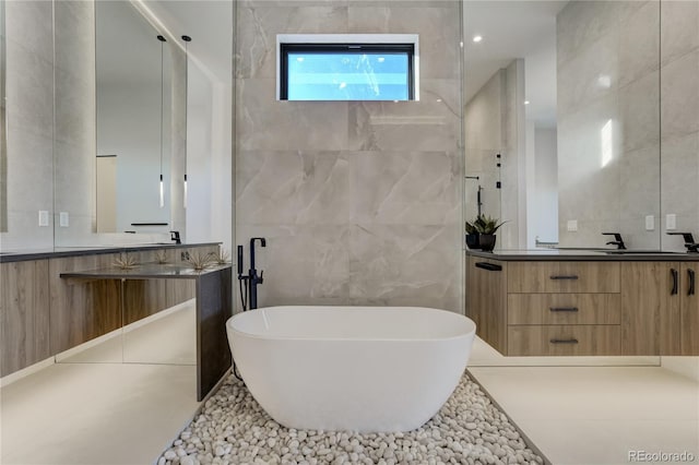 full bathroom with a soaking tub, tile walls, and vanity