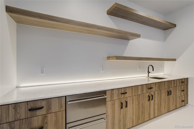 kitchen featuring open shelves, a sink, and light countertops