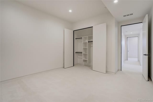 unfurnished bedroom with light colored carpet, a closet, visible vents, and recessed lighting