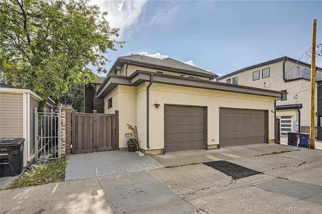 460 N Garfield St, Denver, CO 80206 - view of front of house featuring a gate, stucco siding, an attached garage, and driveway