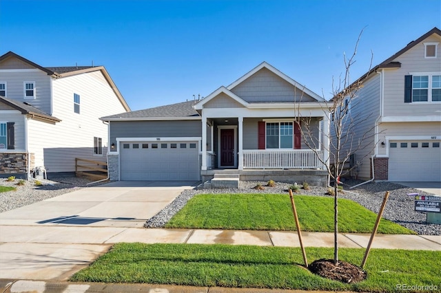 craftsman house featuring covered porch, a front lawn, and a garage