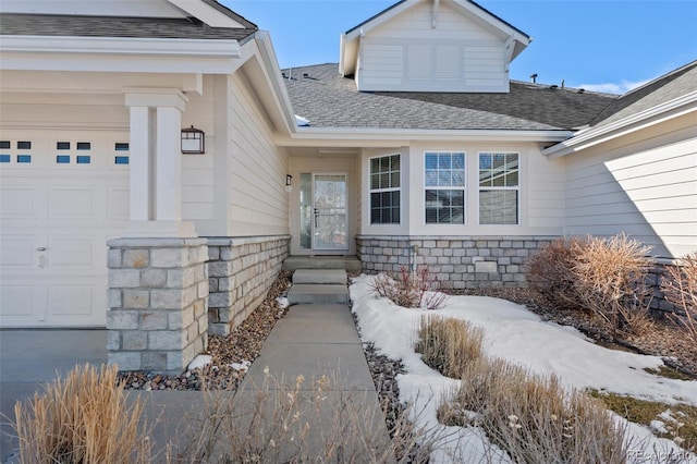 snow covered property entrance featuring a garage