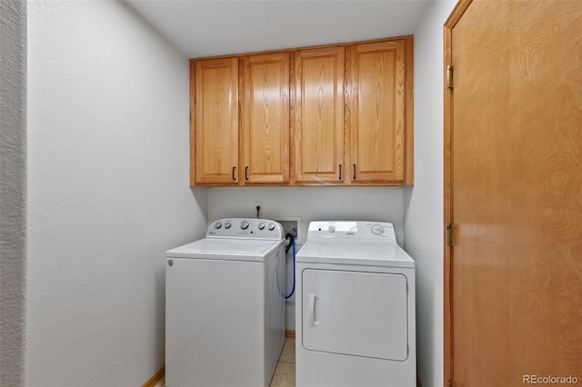 clothes washing area featuring cabinets and separate washer and dryer