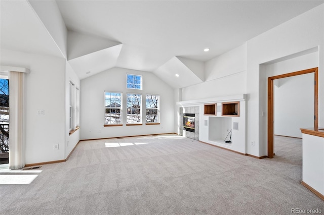 unfurnished living room with light carpet, high vaulted ceiling, and a tile fireplace