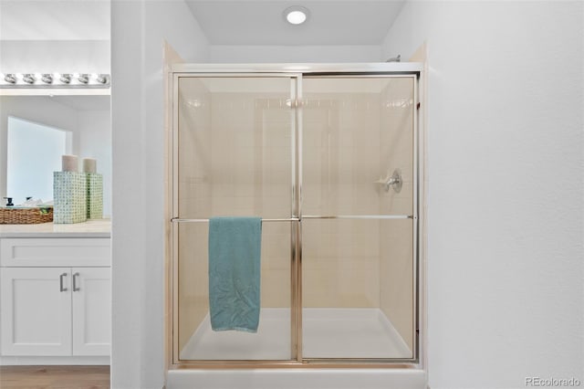 bathroom featuring a shower with door and hardwood / wood-style floors