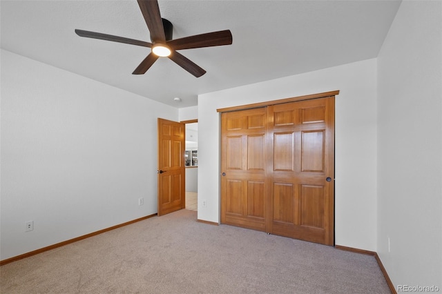 unfurnished bedroom featuring ceiling fan, light colored carpet, and a closet