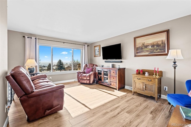 living area with light wood-style flooring and baseboards