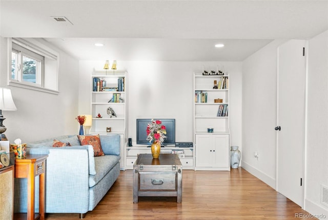 living area with light wood-style floors, recessed lighting, and visible vents