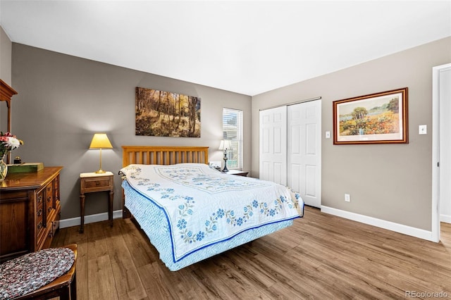 bedroom featuring a closet, baseboards, and wood finished floors