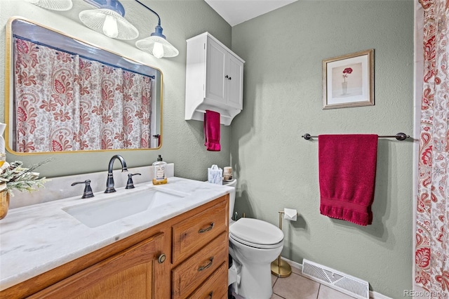 bathroom featuring toilet, vanity, baseboards, visible vents, and tile patterned floors