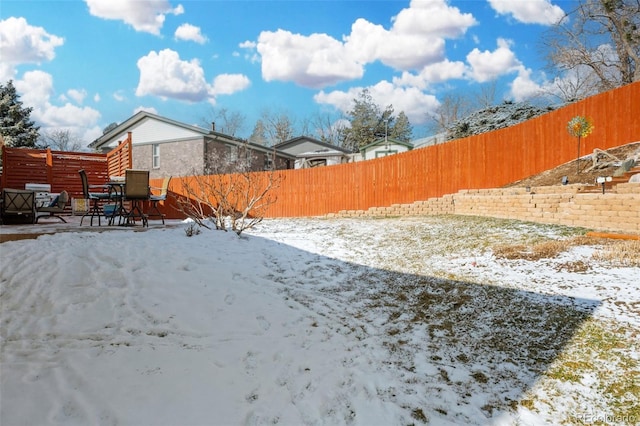 yard layered in snow featuring a fenced backyard