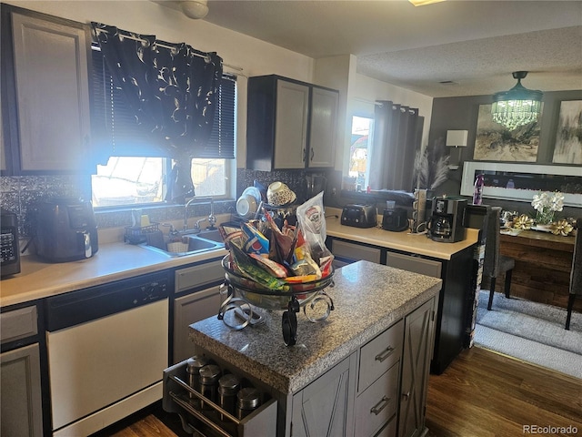 kitchen featuring tasteful backsplash, dishwasher, dark hardwood / wood-style floors, gray cabinets, and sink