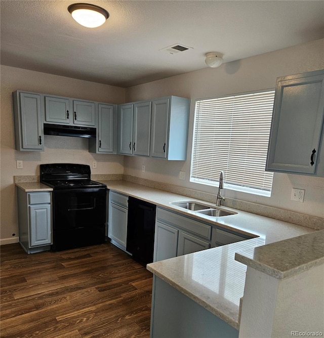 kitchen with visible vents, under cabinet range hood, dark wood finished floors, black appliances, and a sink