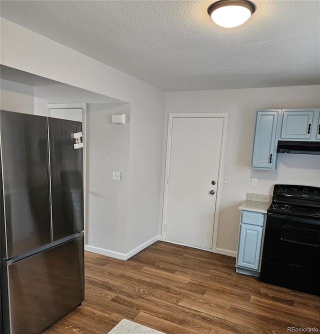 kitchen with dark wood-type flooring, under cabinet range hood, black range oven, freestanding refrigerator, and a textured ceiling