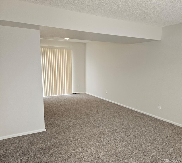 carpeted empty room featuring baseboards and a textured ceiling