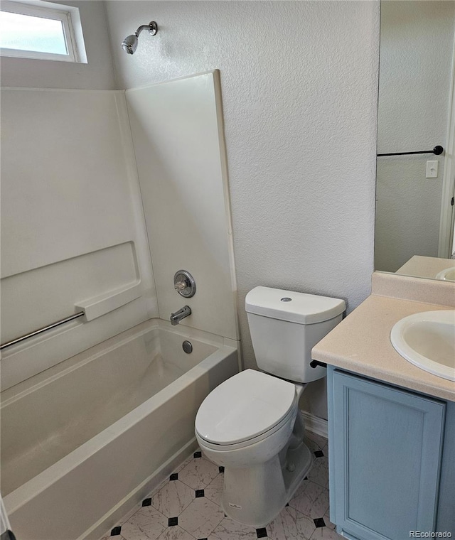 bathroom featuring vanity, shower / bathing tub combination, toilet, and a textured wall