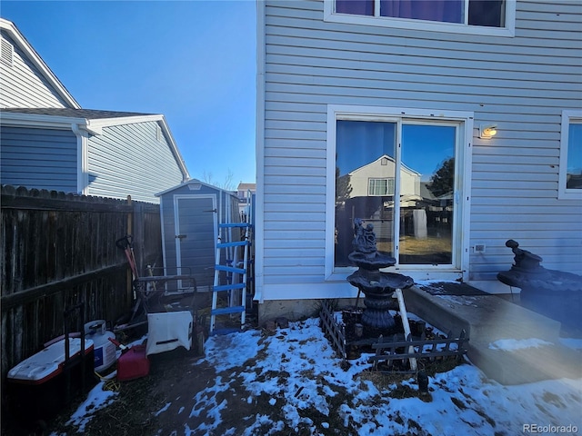 snow covered property entrance with fence