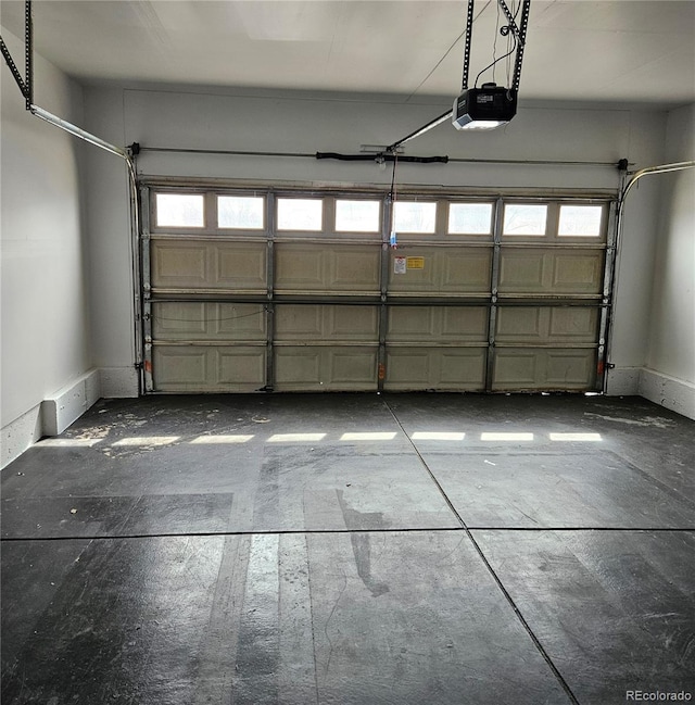 garage featuring a garage door opener and baseboards