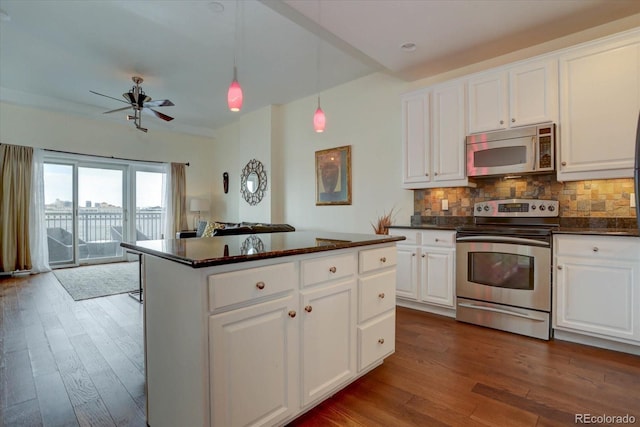 kitchen with tasteful backsplash, white cabinets, stainless steel appliances, and dark hardwood / wood-style floors