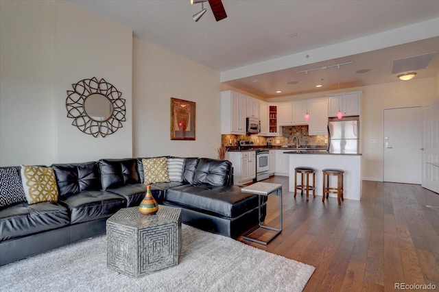 living room with ceiling fan, sink, and wood-type flooring