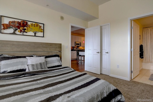 bedroom featuring light carpet and ensuite bath